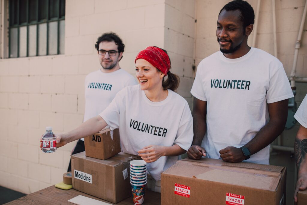 Three Volunteers Donating Goods for Charity including medicine and water