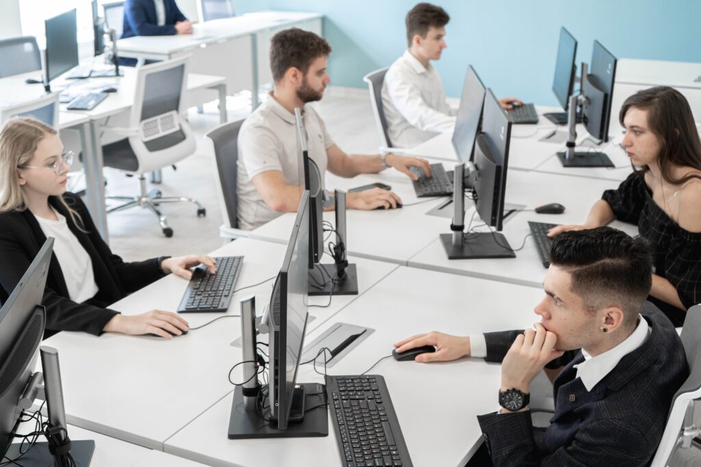 Higher Engineering School of the Russian University of Transport, 5 people sat at a white desk looking at computer screens to portrait a hackathon