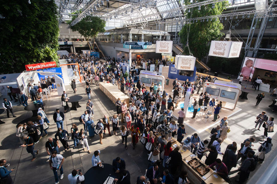 A crowd of people gathers at the European Society of Pediatric Gastroenterology, Hepatology and Nutrition (ESPGHAN) World Congress, with displays that relate to the health of patients and the Family Education Day that helped connect patients to medical experts as part of the event's legacy.