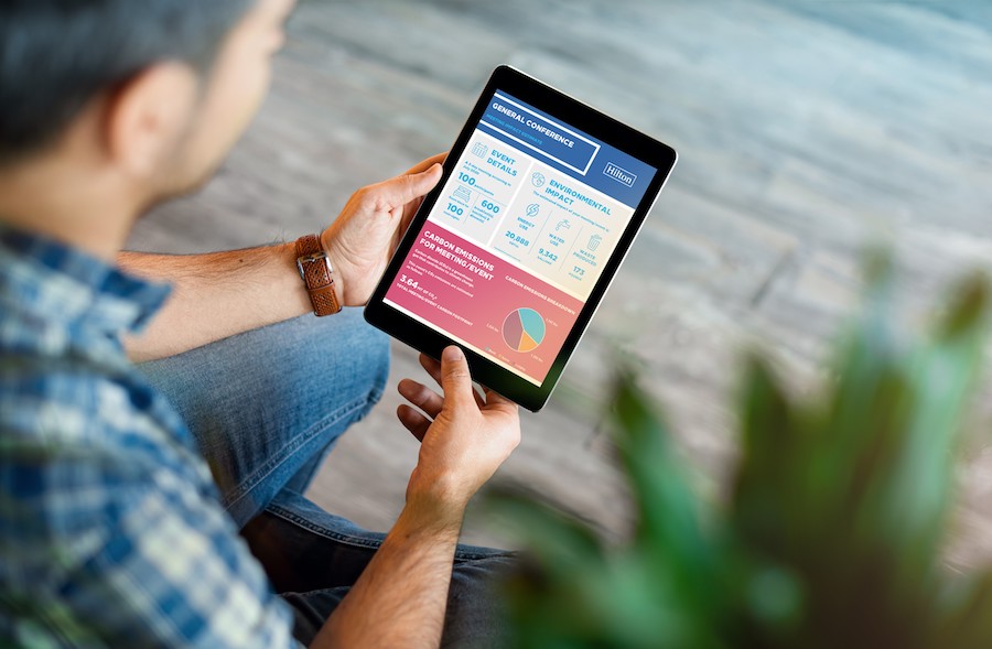 A male meeting professional looks down at a tablet 