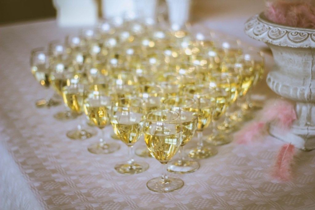 Wine glasses laid out on table filled with white wine