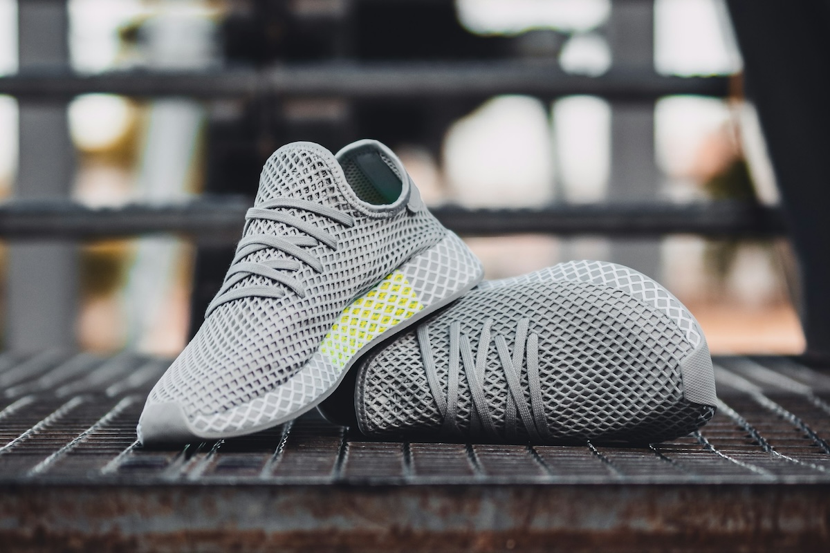 Pair of new grey sneakers laying outside on a metal staircase