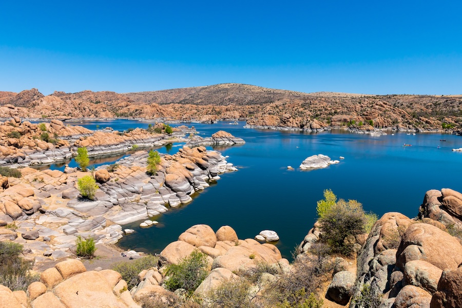 Globular rock formations surround a placid blue lake, the perfect setting for a hike.
