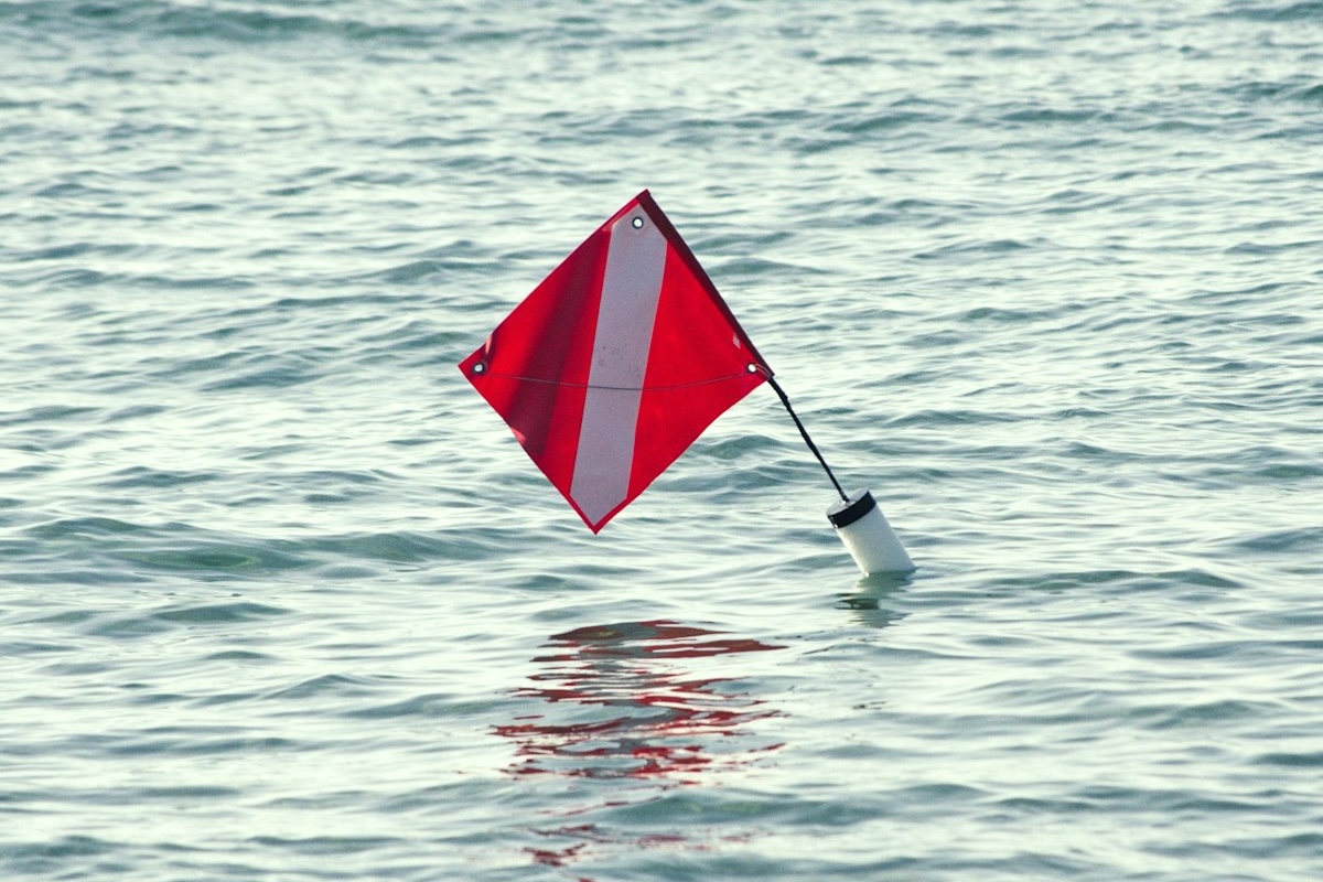 Red warning flag on floating device in water
